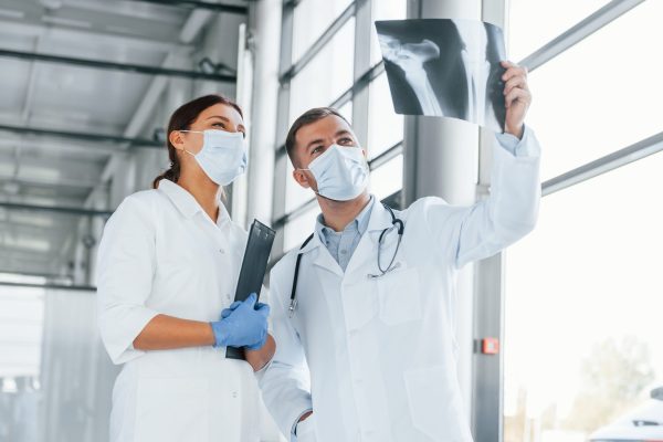 Having busy day. Two doctors in white coats is in the clinic working together